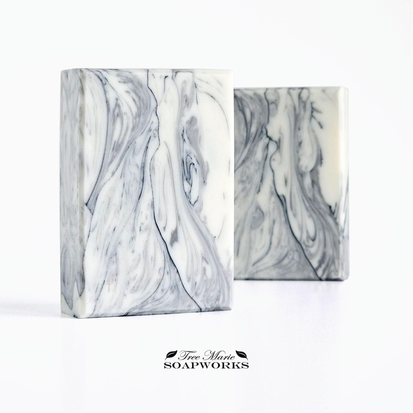 Marble Study artisan soap with flowing gray and black veining on a pale background, shown in two bars.